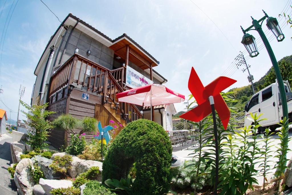 a house with an umbrella in front of it at Geoje Blueberry Pension in Geoje 