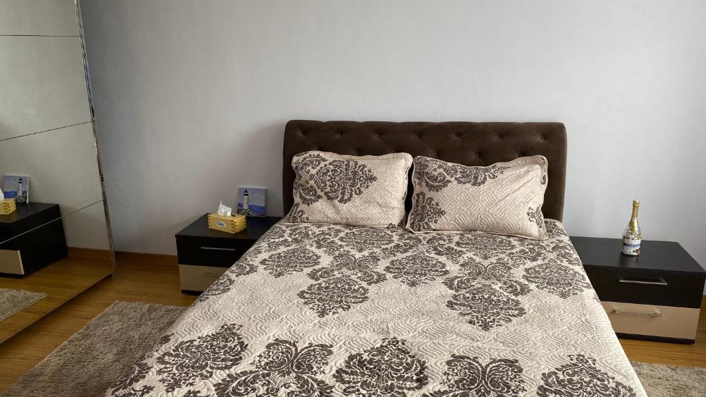 a bed with a black and white comforter and pillows at Arician full service in Ocna Şugatag