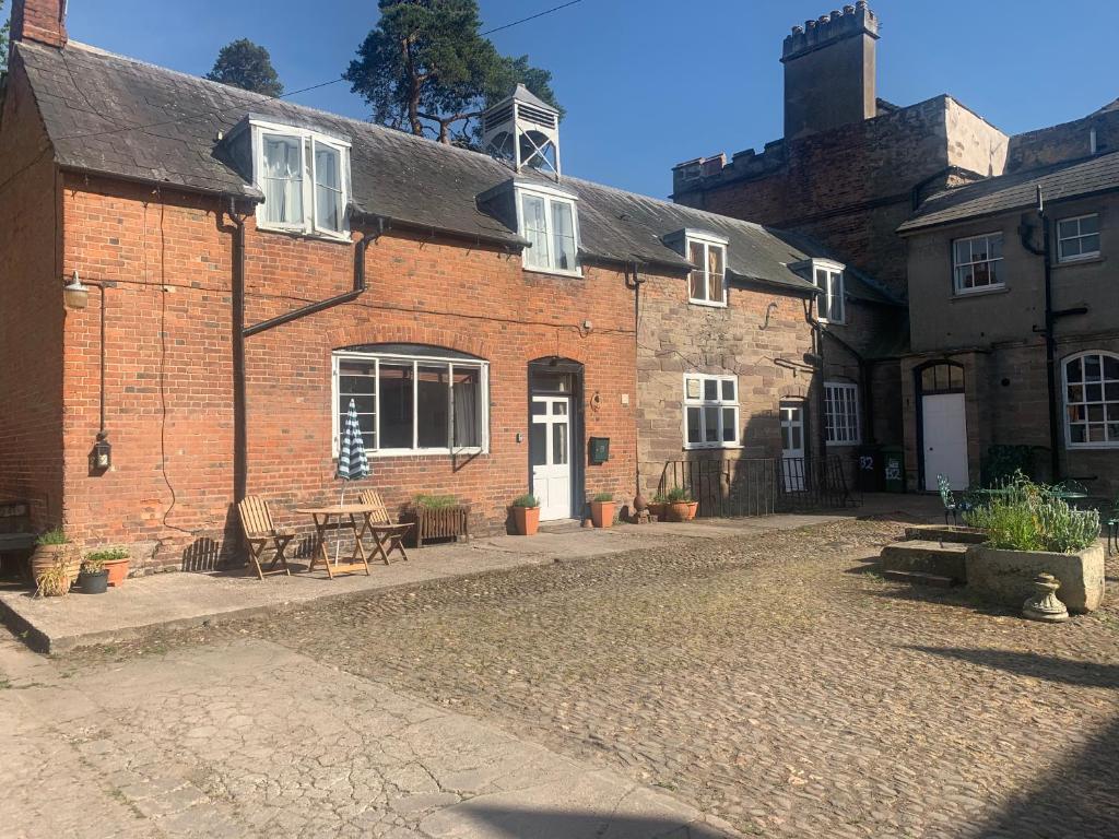 an old brick building with a table in front of it at Lavender Cottage in Hereford