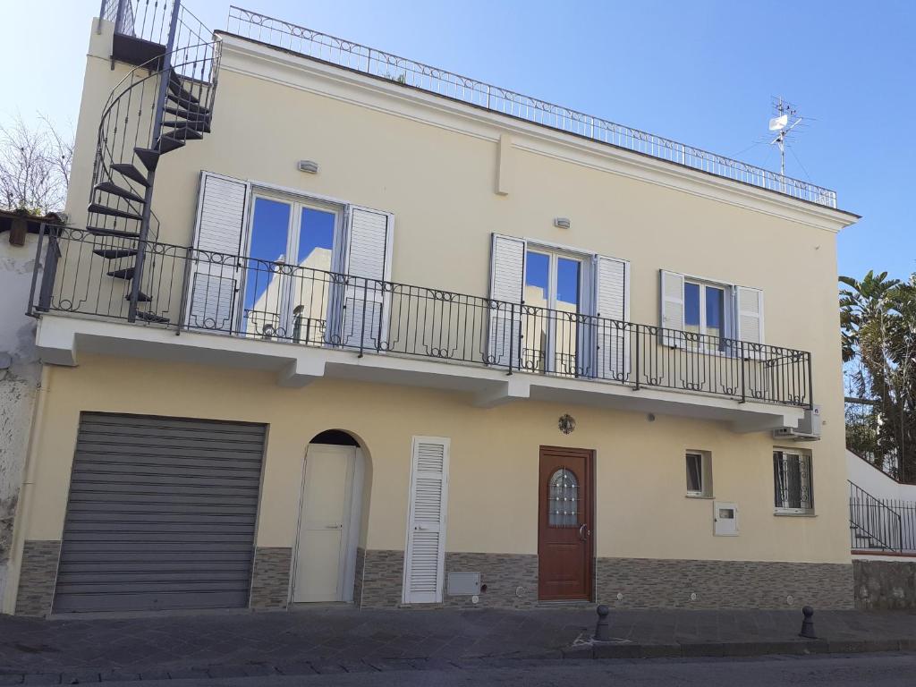 a white building with a balcony and a door at Da Raff in Lacco Ameno