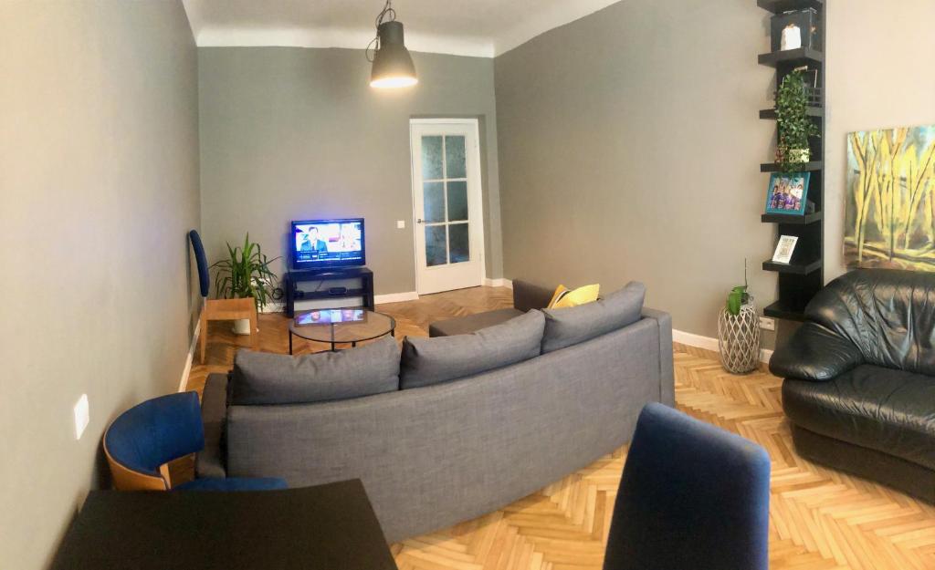 sala de estar con sofá y TV en New comfortable apartment nearby promenade in 5 minutes from Old town of Riga. en Riga