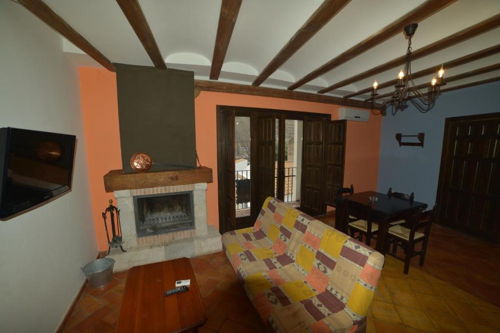sala de estar con sofá y chimenea en Apartamentos Rurales Puerta del Sol, en Alcalá del Júcar