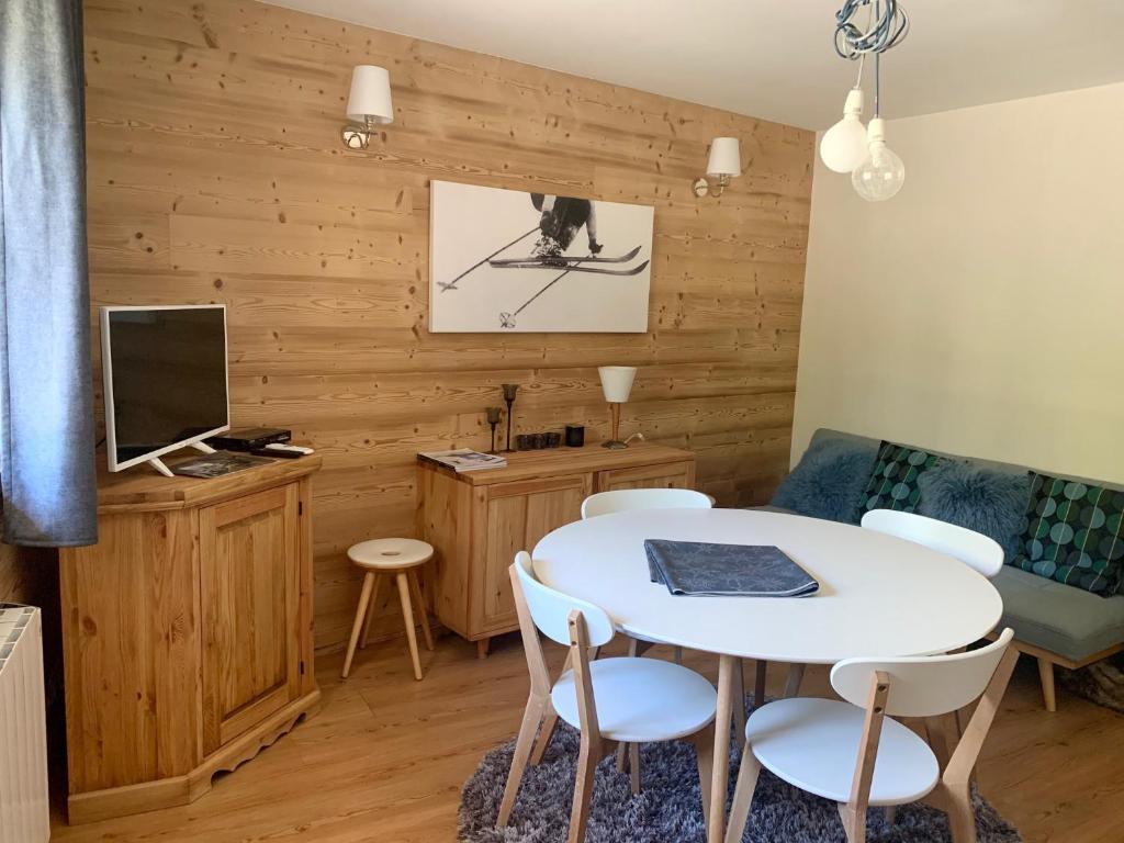 sala de estar con mesa blanca y sillas en La Maison De Marie, en Le Monêtier-les-Bains