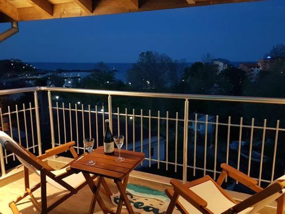 a balcony with a table and two glasses of wine at Deluxe Aquamarine in Ahtopol