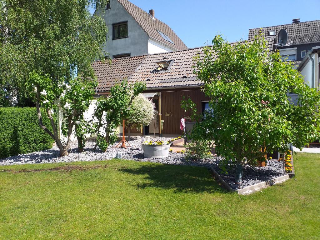 uma casa com um quintal com árvores e uma casa em gemütliches, freistehendes Ferienhaus em Koblenz