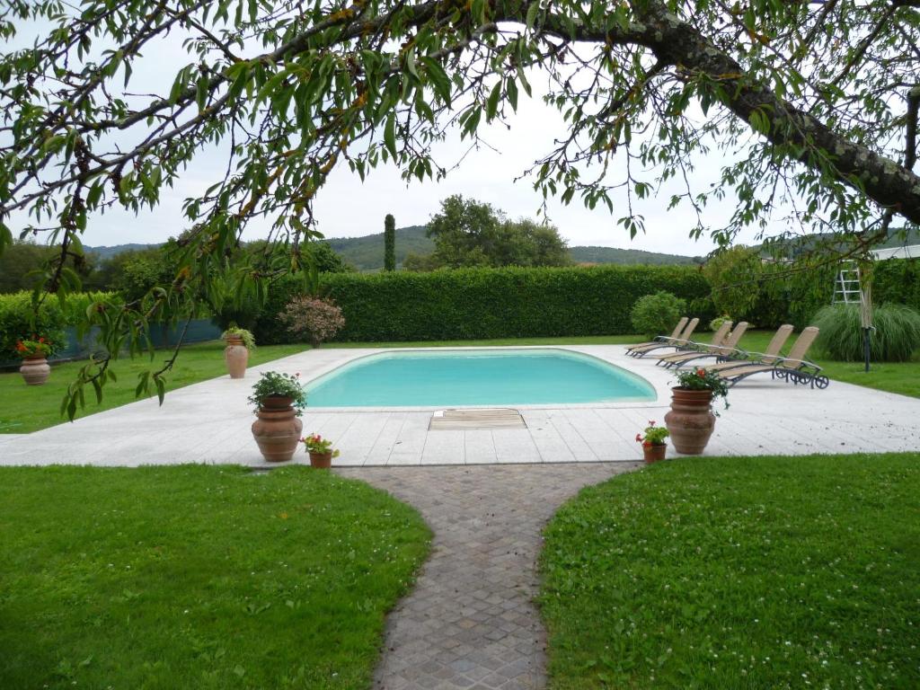 una piscina in un cortile con sedie intorno di Villa Casa Gemelli a Capolona