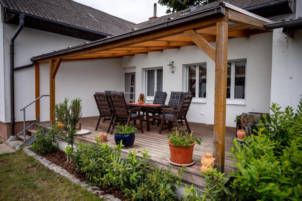 eine Holzterrasse mit einem Tisch und Stühlen darauf in der Unterkunft Winzerferienhaus Schuller in Purbach am Neusiedlersee