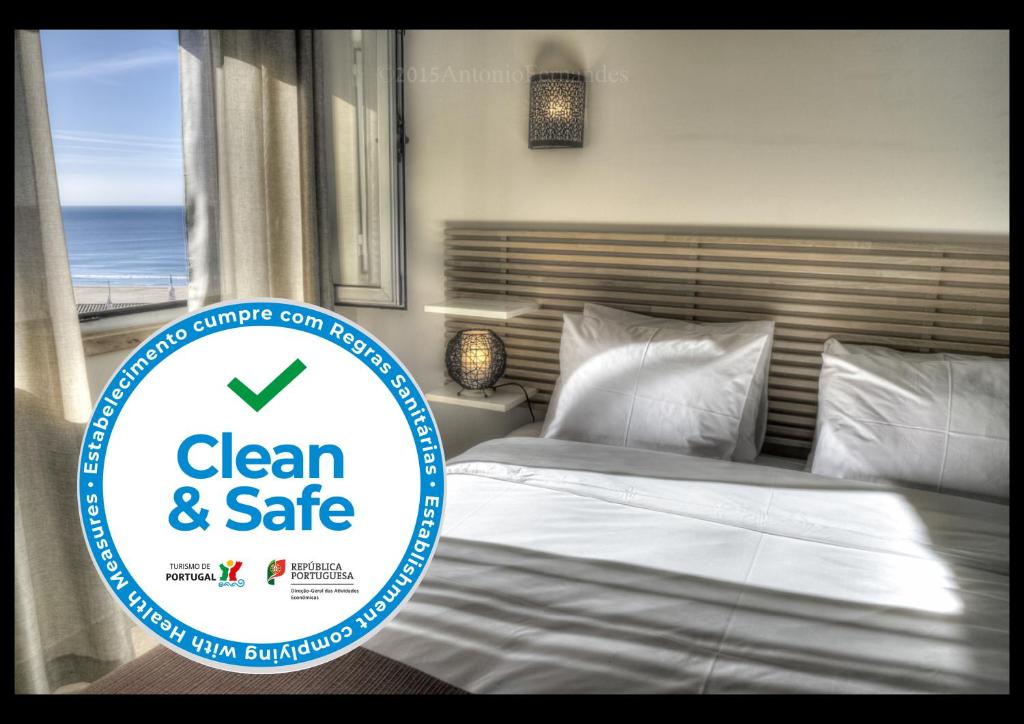 a bedroom with a clean and safe sign next to a bed at Apartamentos Belo Horizonte in Portimão