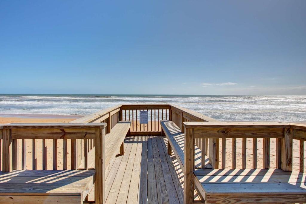 a wooden pier with the ocean in the background at Ocean Watch Condo Unit #105 in Ormond Beach