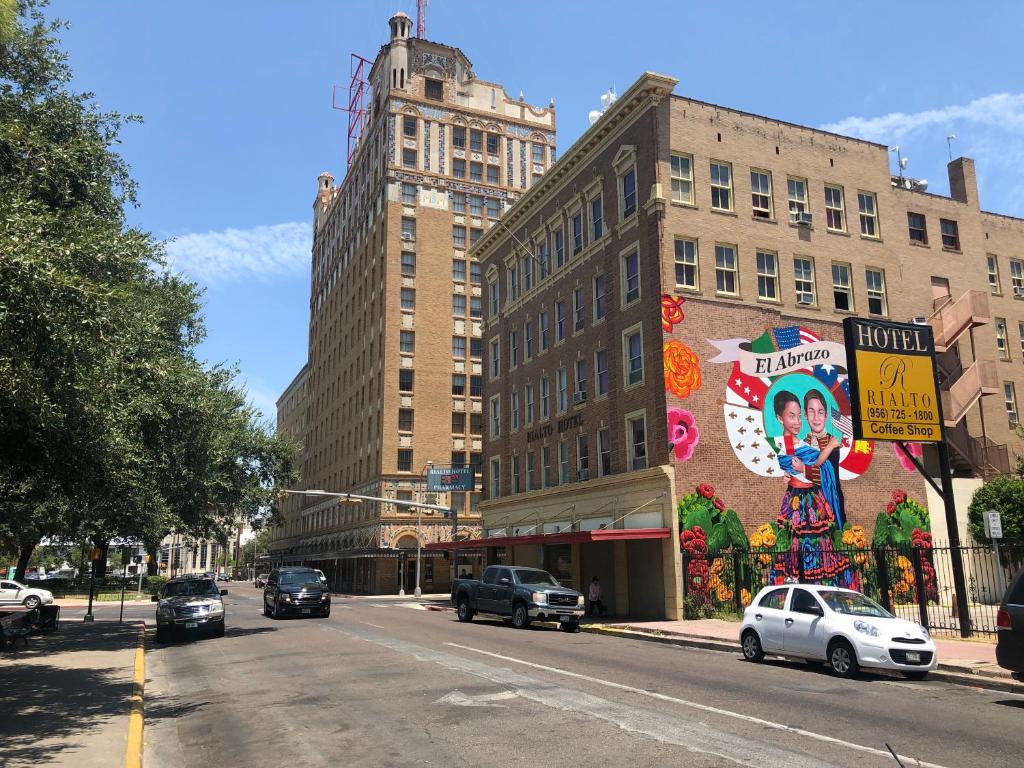 una calle de la ciudad con coches conduciendo por una calle con edificios en The Rialto Hotel, en Laredo