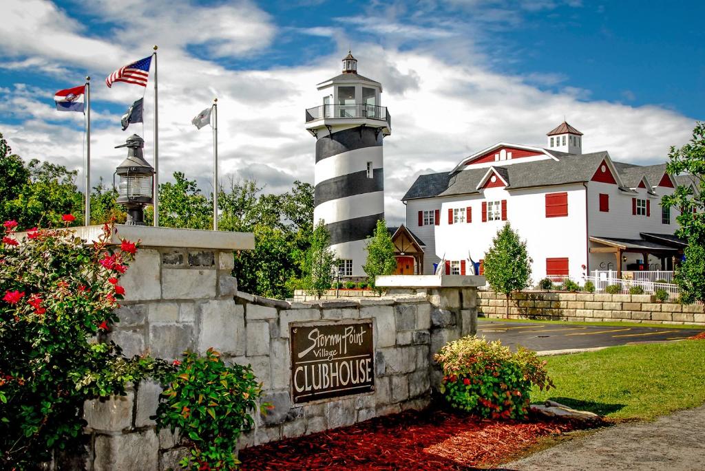a lighthouse in front of a white building with flags at Stormy Point Village Lakeside in Branson
