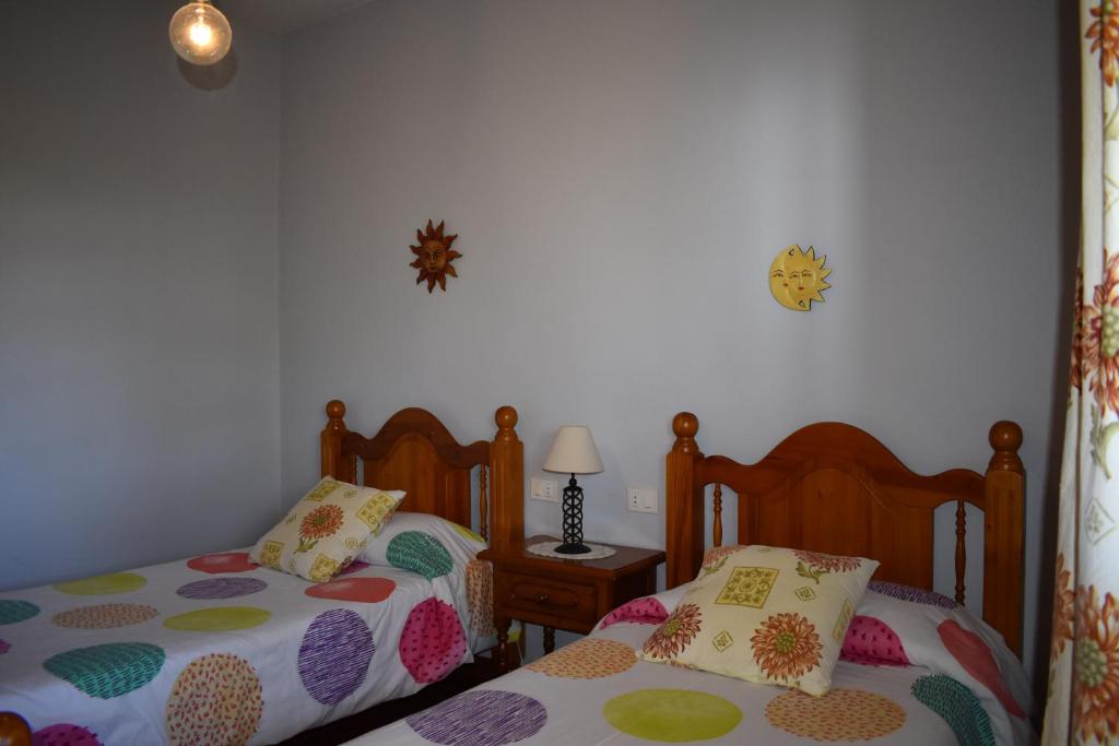 een slaapkamer met 2 aparte bedden en een tafel met een lamp bij Casa Rosa in Tijarafe