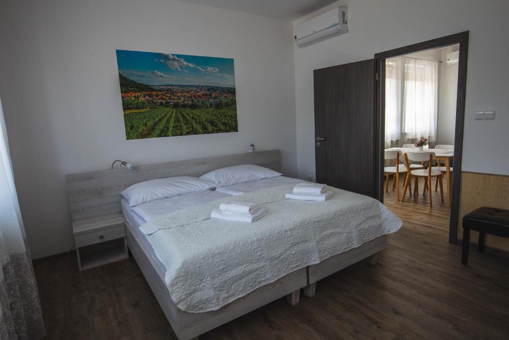 1 dormitorio con 1 cama, mesa y sillas en Apartmány Pemag Mikulov en Mikulov