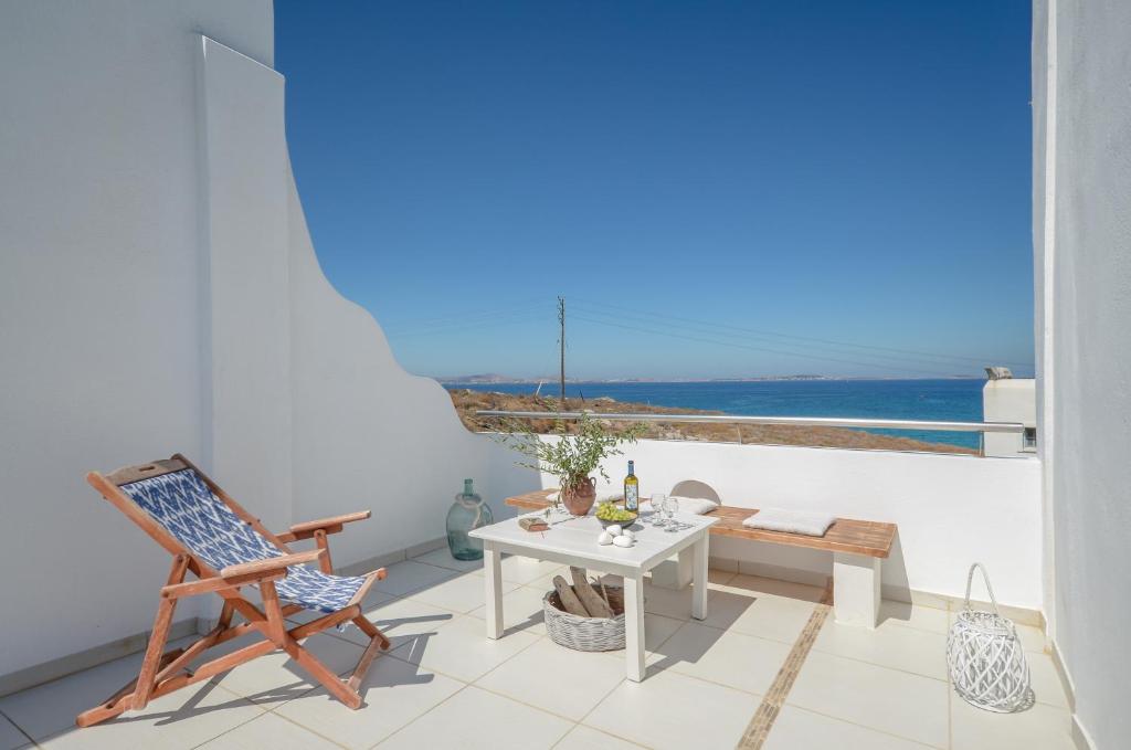 balcone con tavolo, sedie e vista sull'oceano di Akrolithos studios a Stelida