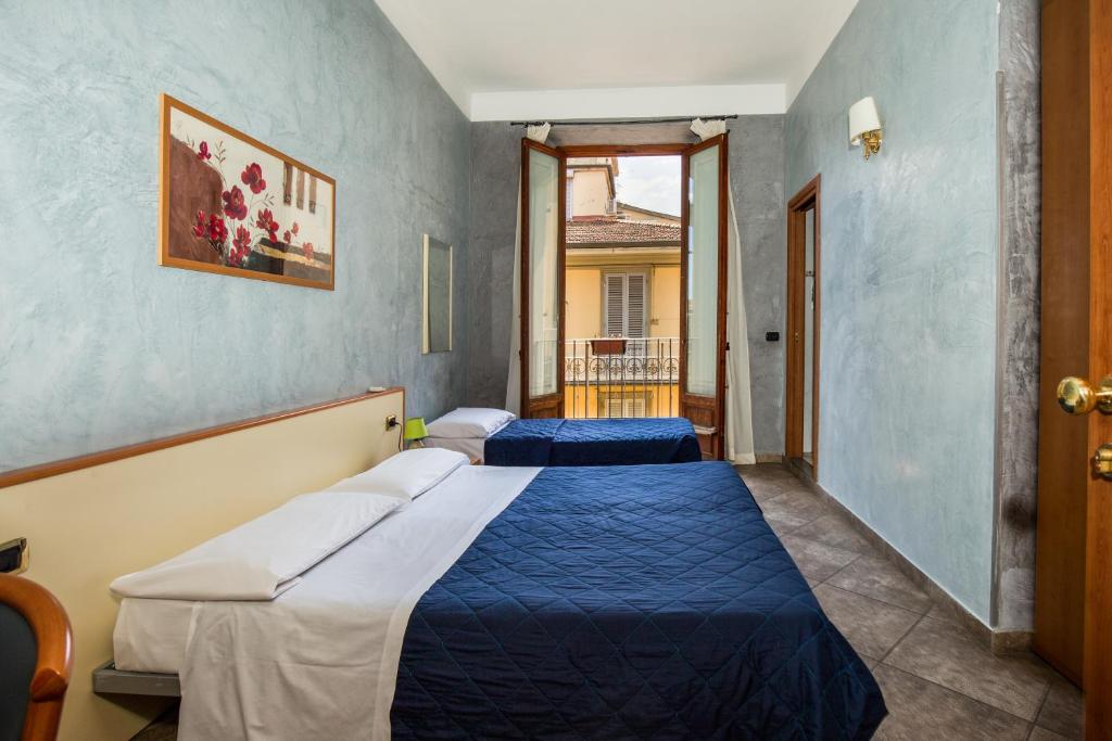 2 Betten in einem Zimmer mit blauen Wänden in der Unterkunft Hotel Angelica " Stazione Santa Maria Novella " in Florenz