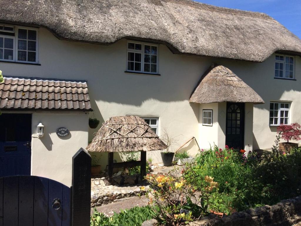 a large white house with a thatched roof at Guest Suite at 31 Little England in Milborne Saint Andrew