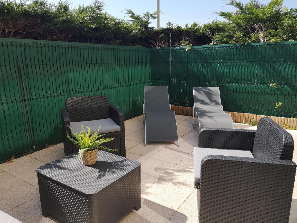 a patio with chairs and tables and a fence at Cabourg plage à 200m plage in Cabourg