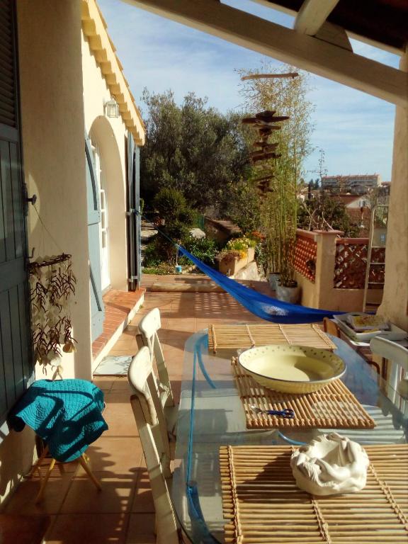 d'une terrasse avec une table en verre et des chaises sur un balcon. dans l'établissement Maison accueillante à Toulon - Jardin privé 90 m², à Toulon