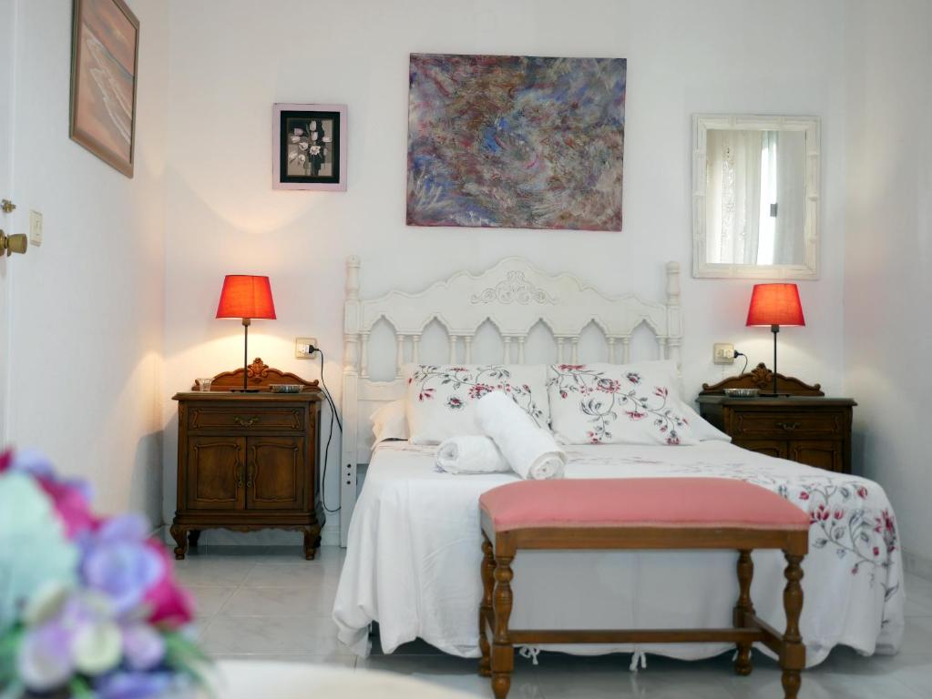 カソルラにあるCasa Rural Los Serranoのベッドルーム(白いベッド1台、ランプ2つ付)