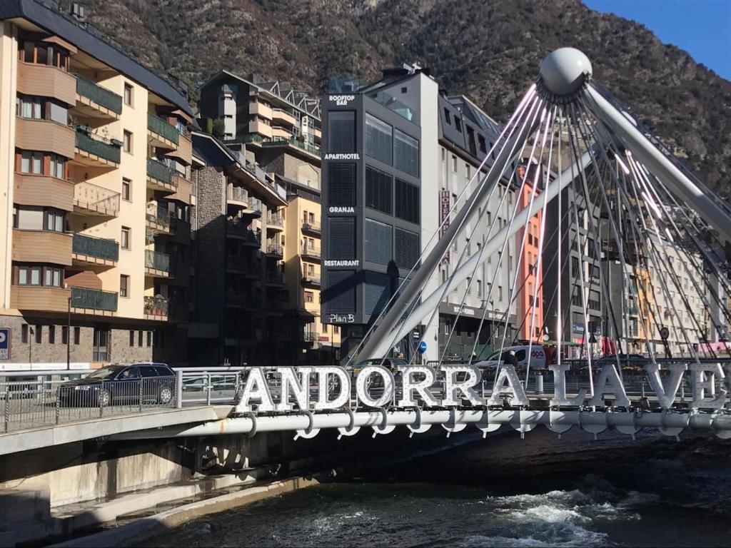 un puente sobre un río en una ciudad con edificios en PLAN B City Center Aparthotel, en Andorra la Vella