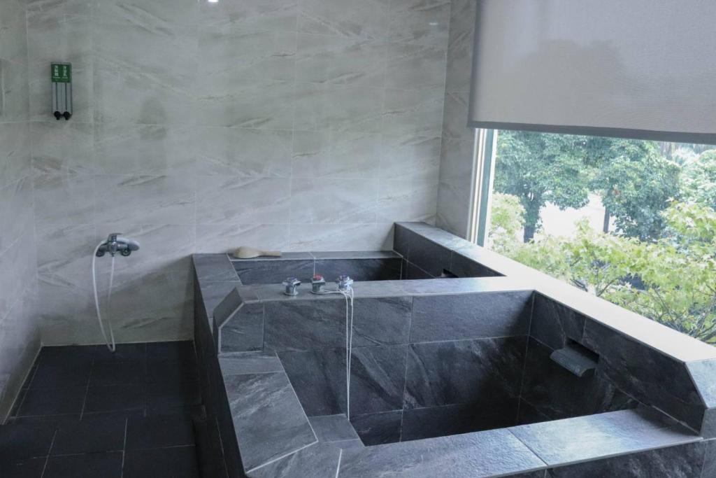 a bathroom with a large tub with a window at The Loft Seaside Suites in Jinshan