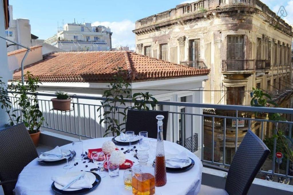 a table on a balcony with a view of a building at OpenAir HOT TUB/Big Balcony/Great Boutique Apt in Athens