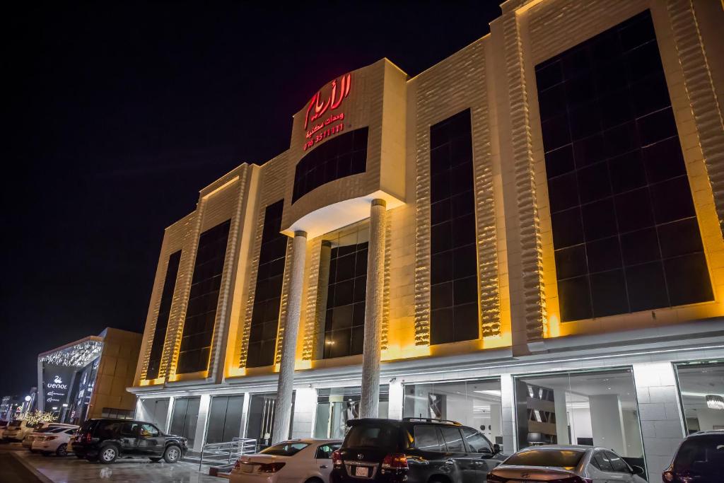 budynek z samochodami zaparkowanymi przed nim w obiekcie Al Aryam Serviced Aparthotel w mieście Burajda