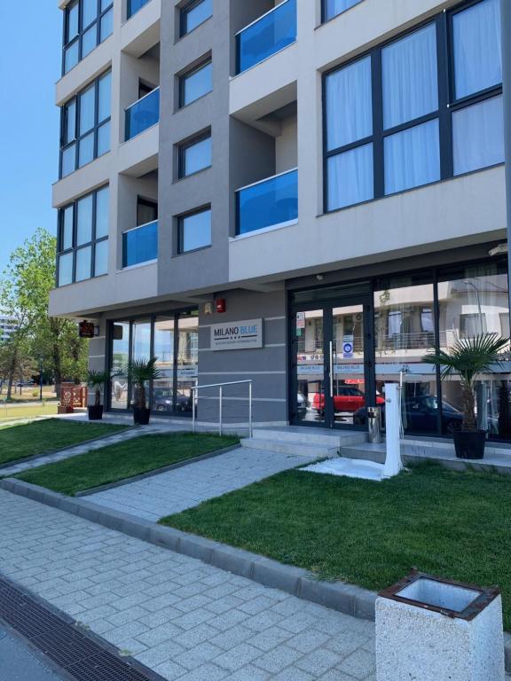 an apartment building with a sidewalk in front of it at Milano Blue Mamaia in Mamaia