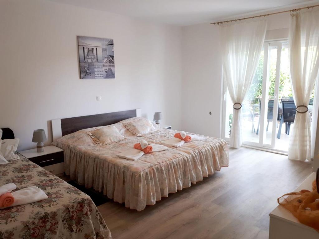 - une chambre avec 2 lits et une grande fenêtre dans l'établissement Apartmani Kulin 2, à Kaštela