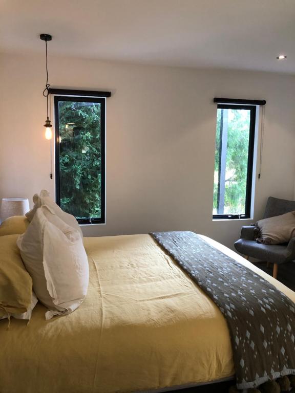 a bedroom with a large bed with two windows at The Stewart in Margaret River Town