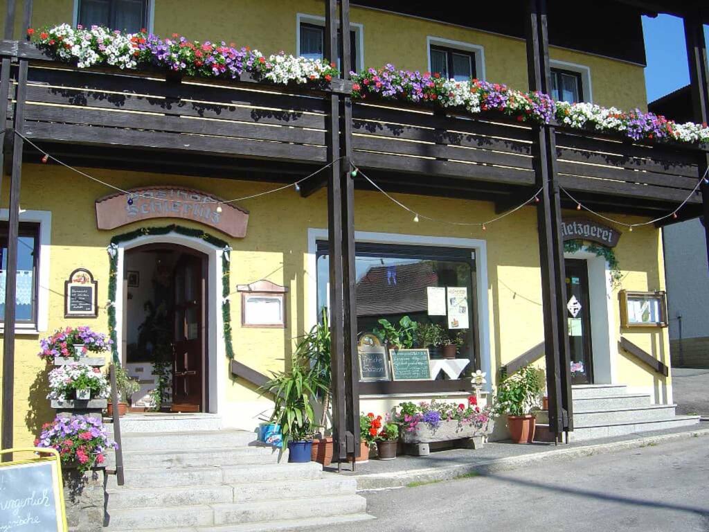 un edificio con flores a un lado. en Gasthof-Metzgerei-Pension Schierlitz, en Rimbach