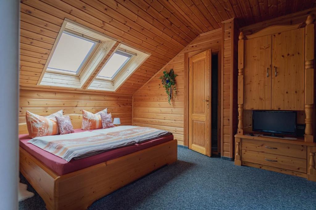 a bedroom with a bed and a tv in a cabin at Gaststätte und Pension Zum Torfstich in Hundshübel