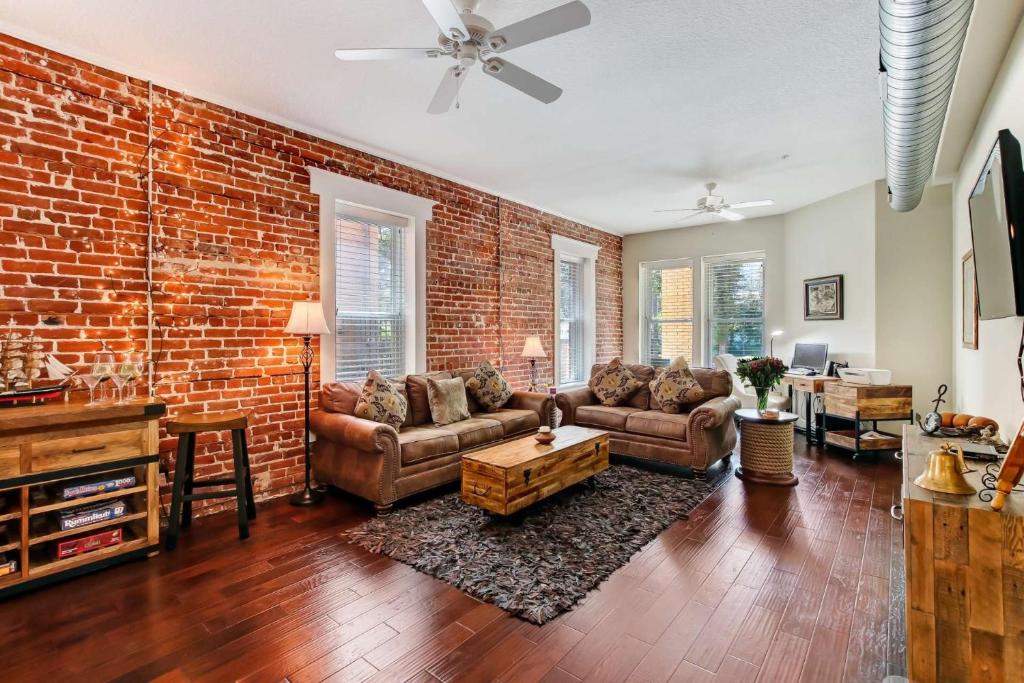 a living room with a brick wall and couches at JBH 115 W 2nd Apt #2 in Jacksonville