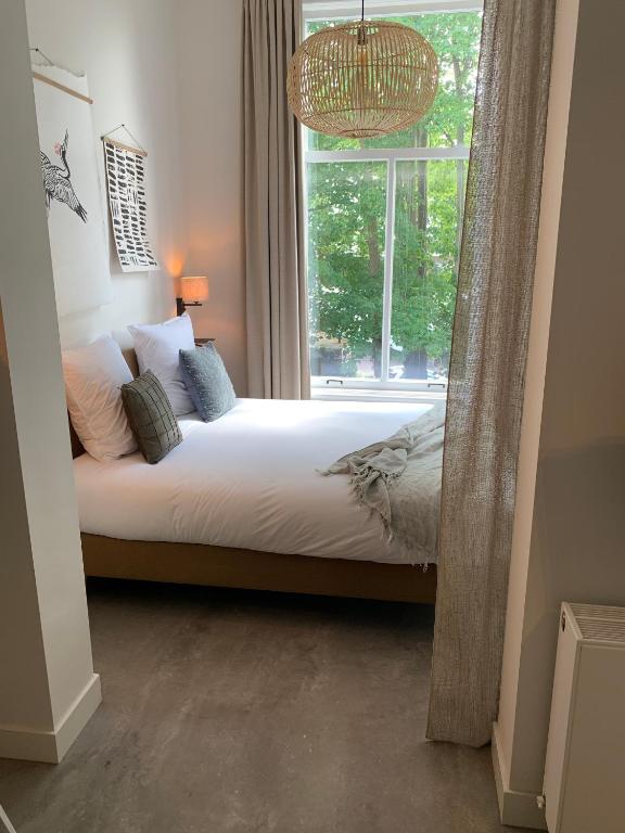 a bedroom with a bed in front of a window at Utrecht City Apartments - Maliesingel in Utrecht