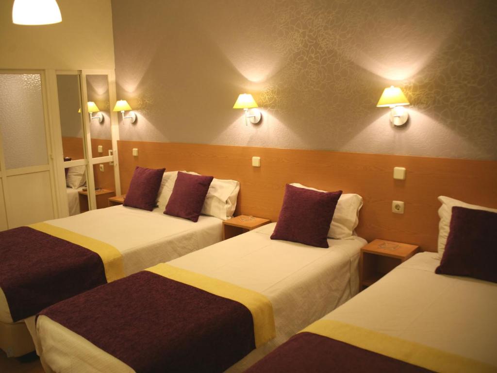 a hotel room with two beds and two lamps at Estrela dos Anjos Guesthouse in Lisbon