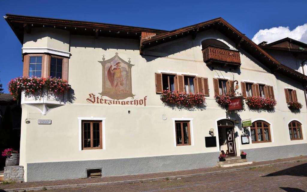 a white building with a statue on the side of it at Sterzingerhof in Vipiteno