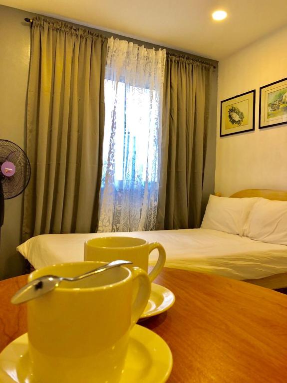 a yellow tea pot on a table next to a bed at Umali Kayo at Megatower Residences II in Baguio