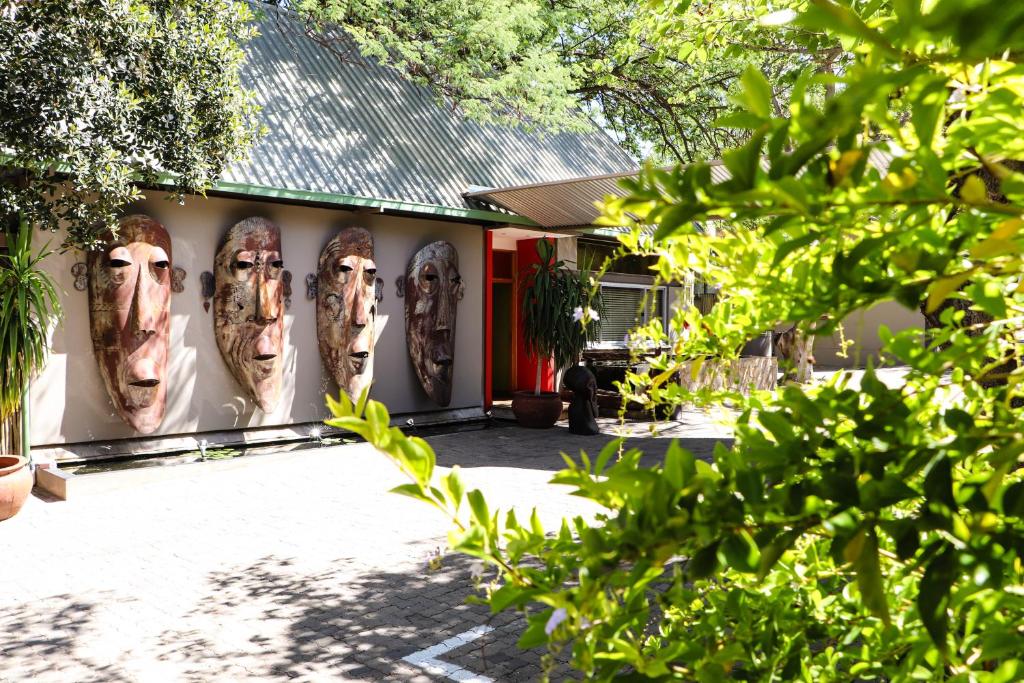 a building with faces painted on the side of it at APS Guesthouse in Windhoek