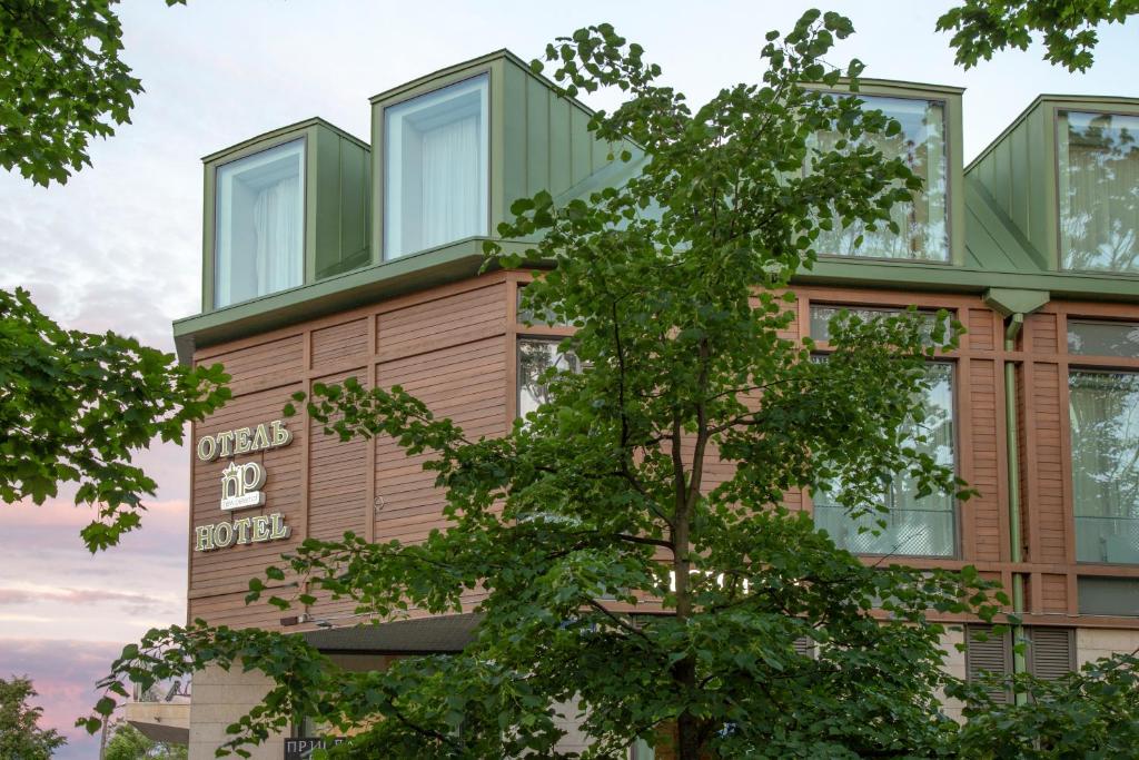 a building with a tree in front of it at New Peterhof Hotel in Petergof