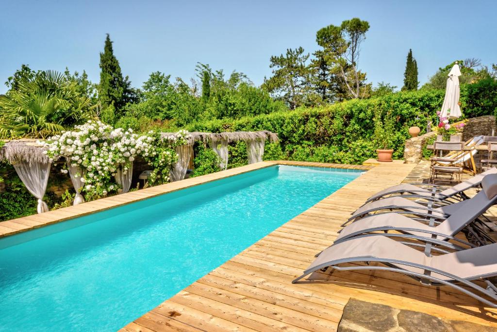 una piscina con sedie e una terrazza in legno di Borgo Marcena ad Arezzo