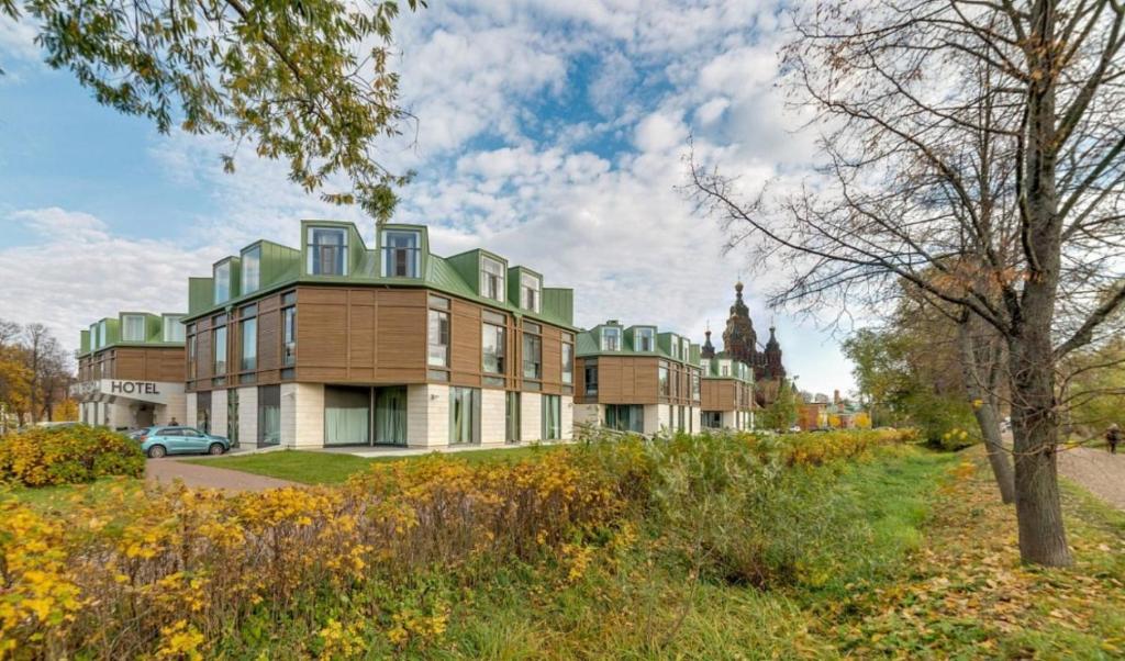 a building with a green roof on a city street at New Peterhof Hotel in Petergof