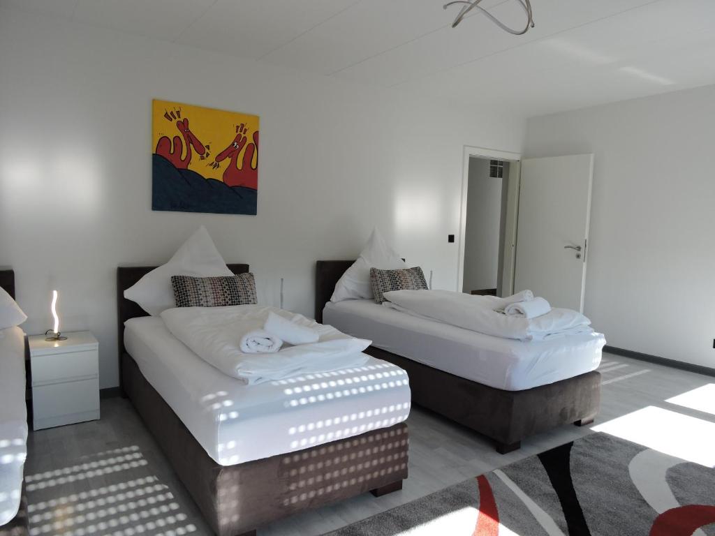 ein Schlafzimmer mit 2 Betten und einem Tisch mit einer Kerze in der Unterkunft Ferienwohnungen große Luise in Saarbrücken