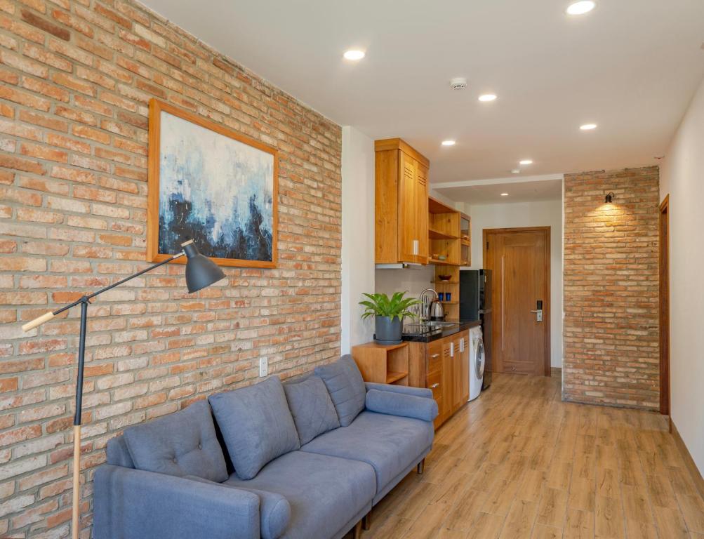 a living room with a couch and a brick wall at Coast House Boutique Hotel in Nha Trang