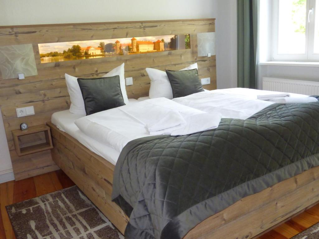 a bedroom with a large bed with a wooden headboard at Gasthof & Fleischerei Endler in Rheinsberg