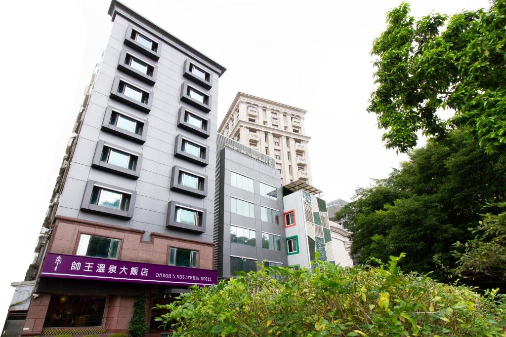 a tall building with a purple sign on it at Baron's Hot Spring Hotel in Jiaoxi