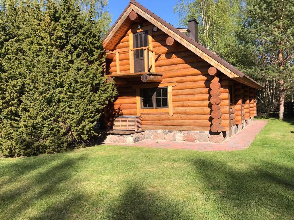 a log cabin with a porch and a window at Excellent log house with a sauna in Lahemaa! in Hara