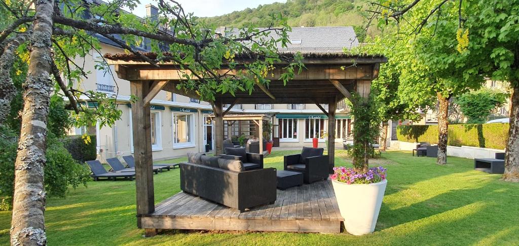 a pergola with couches and chairs in a yard at Le Castelet in Le Mont-Dore