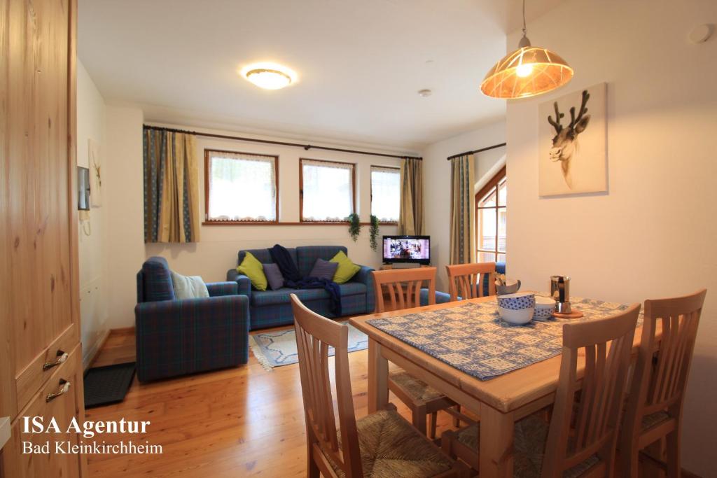 a dining room and living room with a table and chairs at MAIBRUNN Apartment in Bad Kleinkirchheim