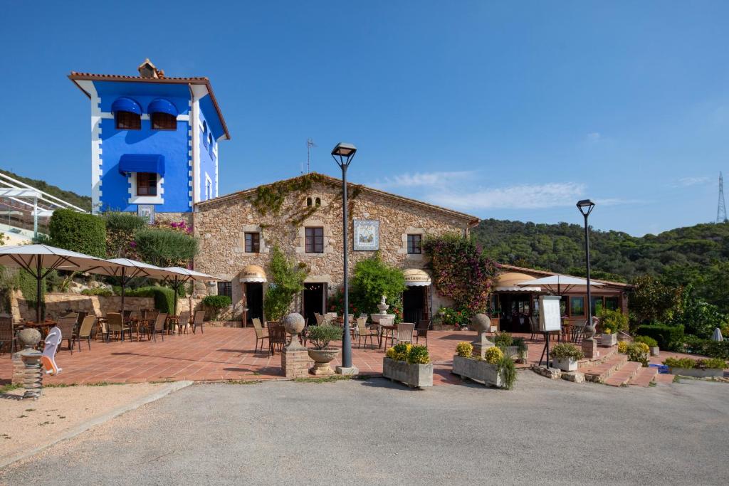 a building with tables and chairs in front of it at Mas Torrellas in Santa Cristina d'Aro