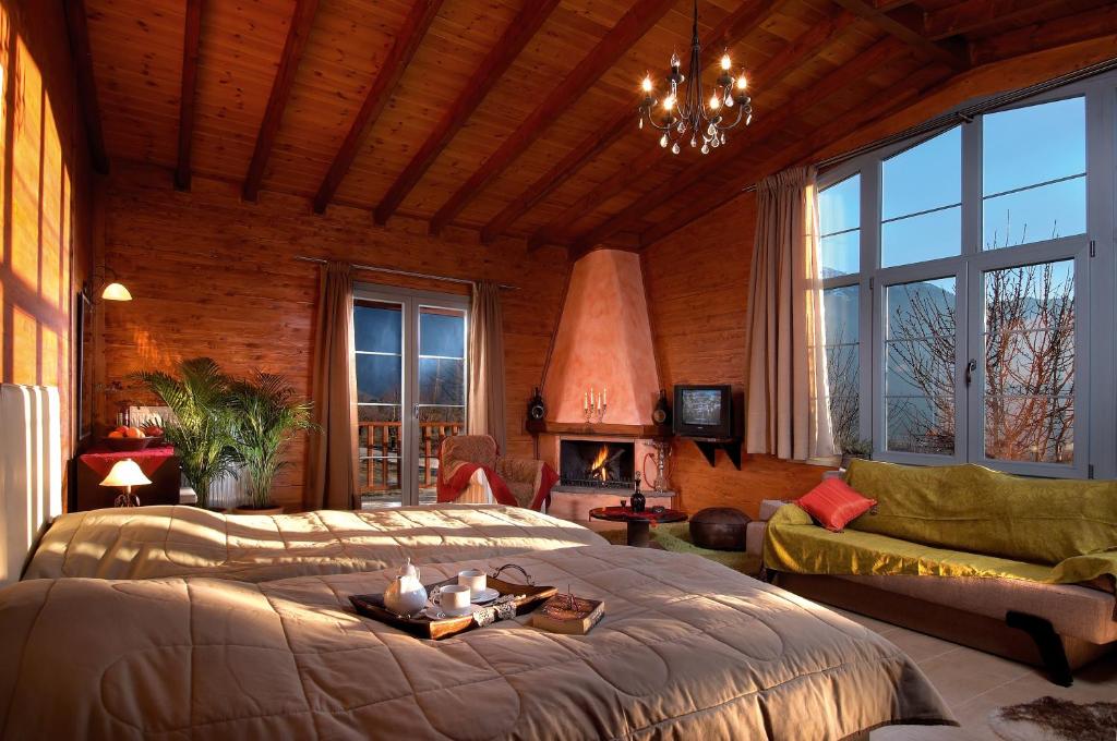 a bedroom with a large bed and a fireplace at Villa Rustica in Konitsa